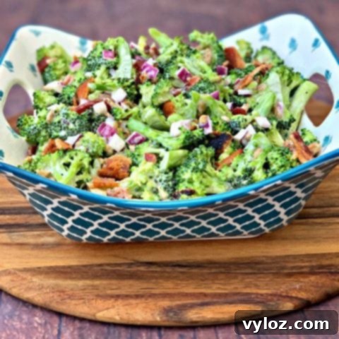 Creamy Keto Low-Carb Broccoli Salad with Bacon, red onions, and sunflower seeds in a blue bowl