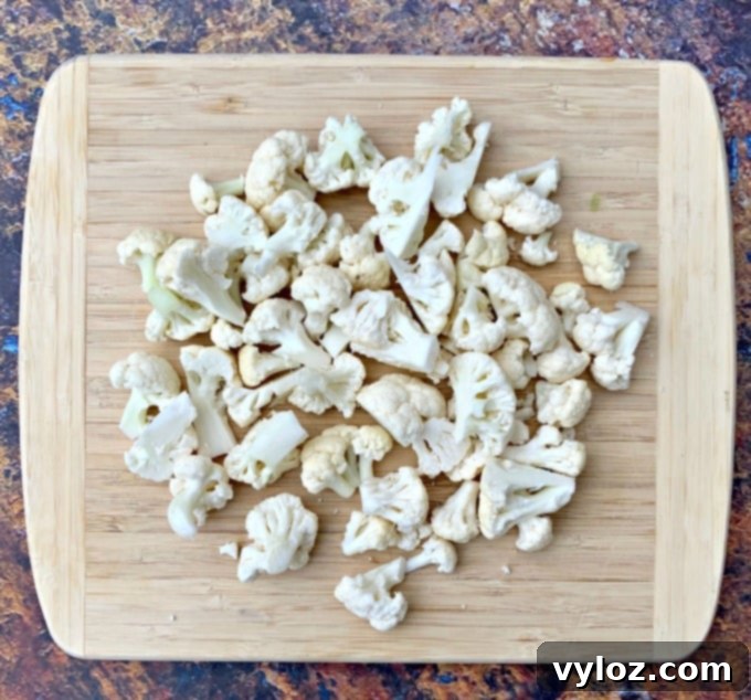 Raw chopped cauliflower on a cutting board