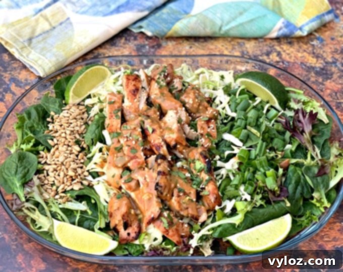 Delicious Chopped Thai Grilled Chicken Salad with creamy peanut dressing on a clear plate