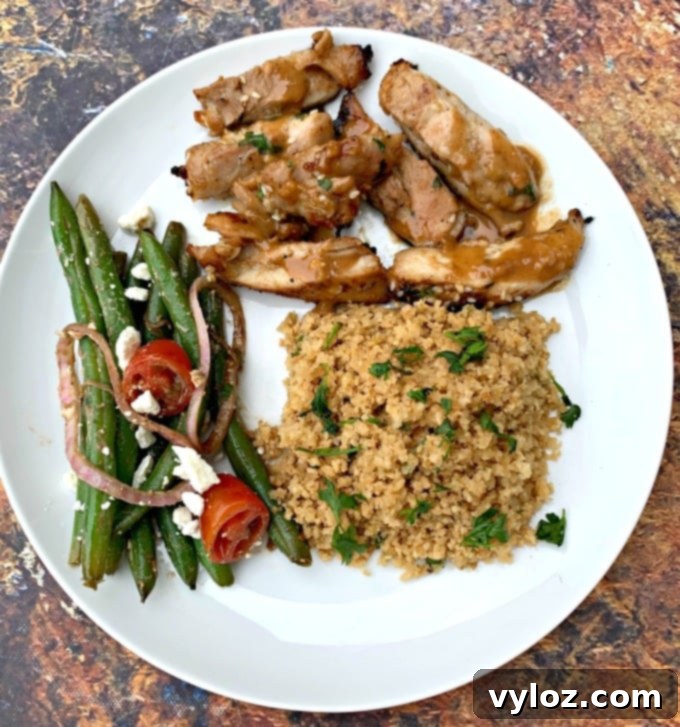 Plated meal prep featuring Thai chicken, green bean salad, and cilantro lime cauliflower rice