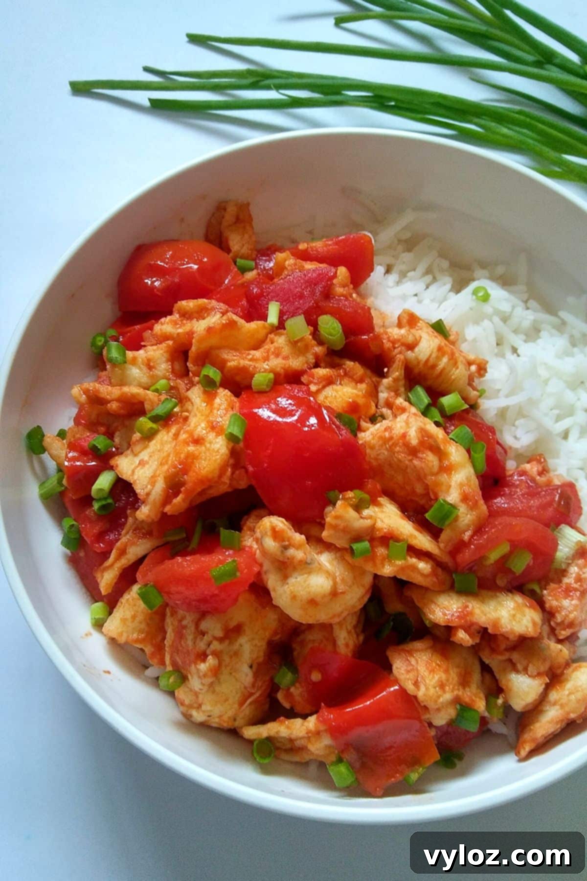 Image showing a close up of tomato egg dish served over steamed rice.