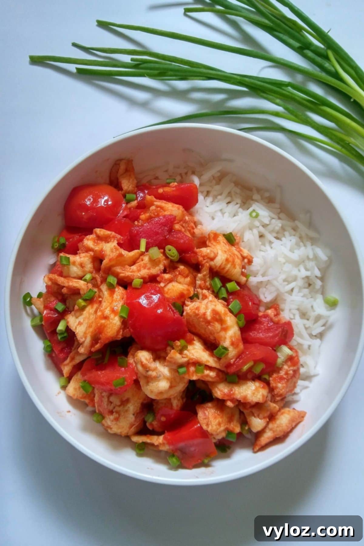 Image showing stir fried tomato eggs served over a bowl of white rice.