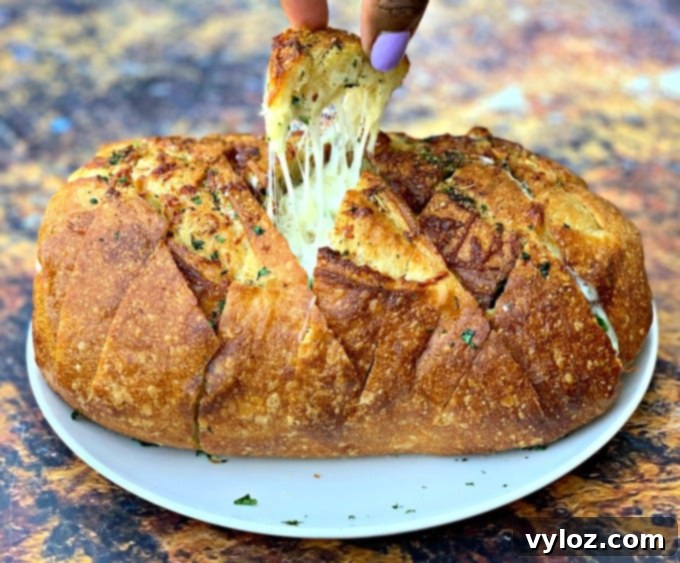 person pulling a piece of air fryer pull apart garlic cheese bread