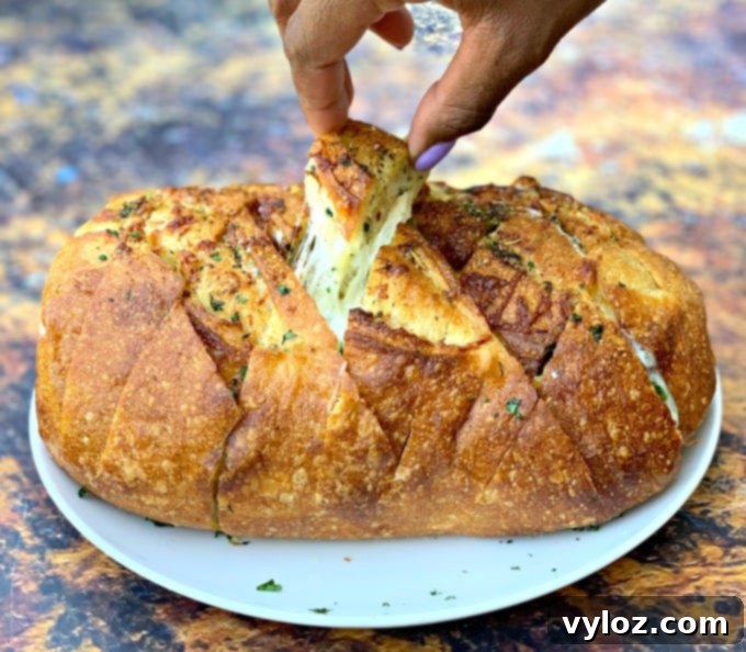 person pulling a piece of air fryer pull apart garlic cheese bread