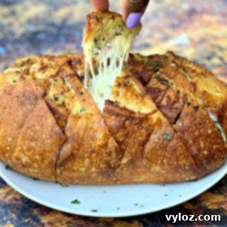 person pulling a piece of air fryer pull apart garlic cheese bread