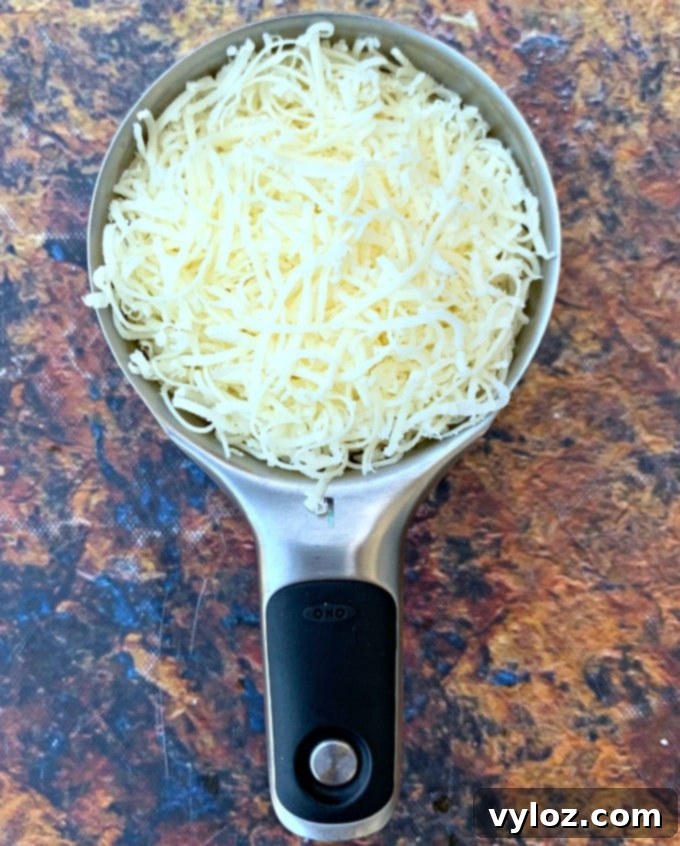 shredded mozzarella cheese in a measuring cup