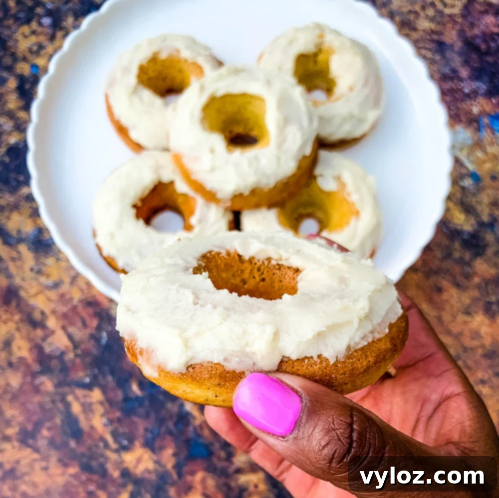 person reaching for a keto low carb donut with frosted glaze