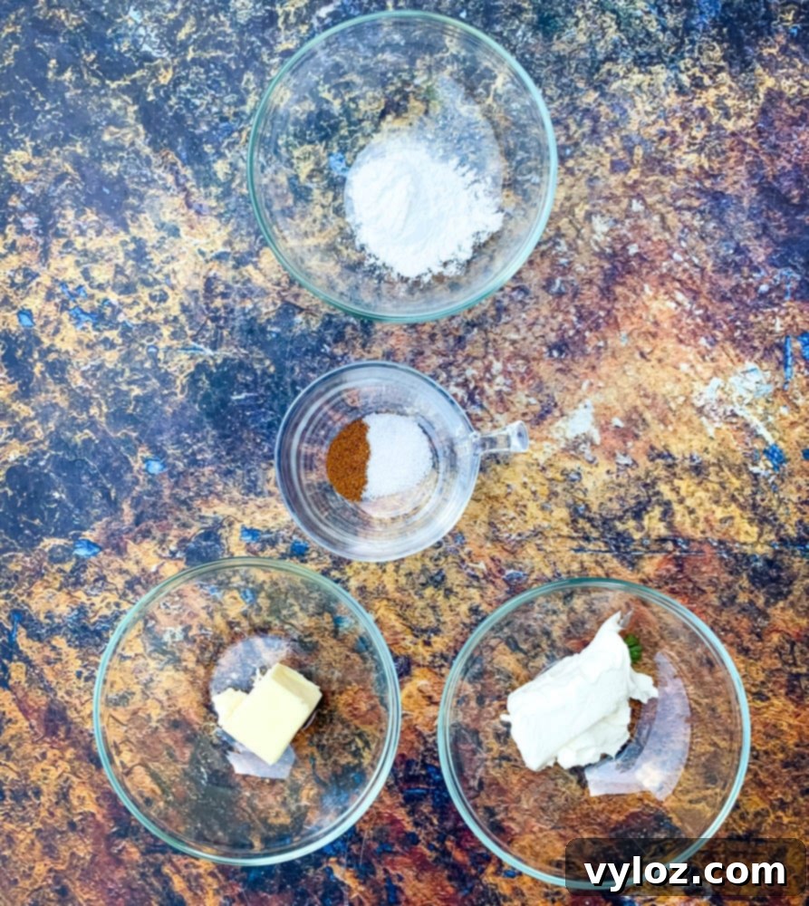 Assortment of keto ingredients laid out for baking, including sweetener, cream cheese, butter, and baking powder.