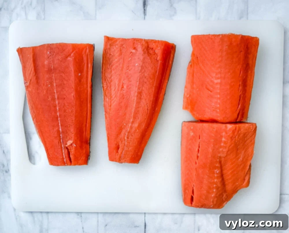 Delicious Air Fryer Salmon Made Simple 3 raw Alaskan salmon on a cutting board