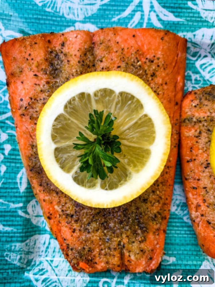 Delicious Air Fryer Salmon Made Simple 6 air fryer salmon on a blue plate with a fresh lemon size