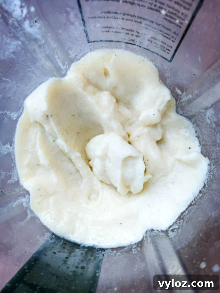 Close-up of the Chick-fil-A Frosted Lemonade blending to a thick, creamy consistency in a blender.