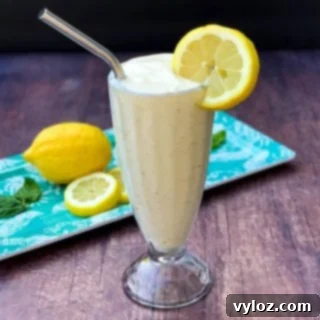 A perfectly blended Chick-fil-A Frosted Lemonade in a glass cup, garnished with a fresh lemon slice and a straw, showcasing its creamy texture.