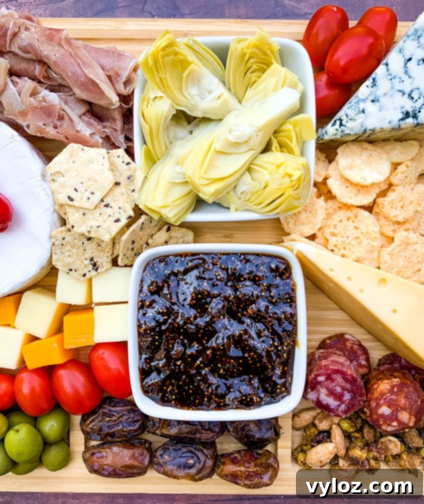 charcuterie board with artichokes, fig spread, cheese, and meat