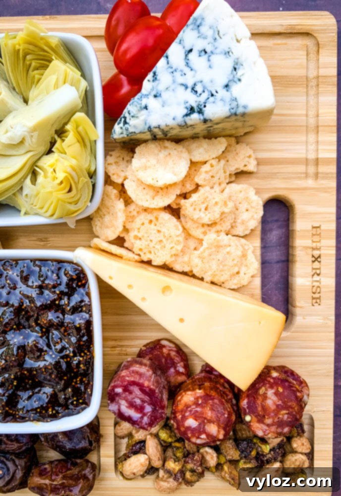 charcuterie board with artichokes, fig spread, cheese, and meat