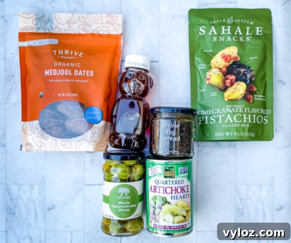 ingredients for charcuterie board olives, artichokes, honey, nuts, and dates