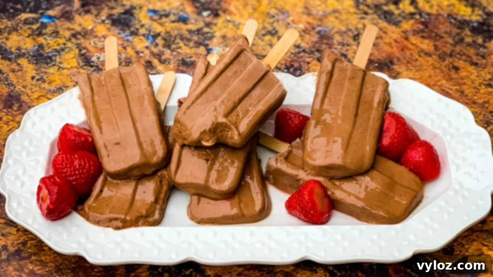 Keto low-carb fudge popsicle bars on a white plate with strawberries