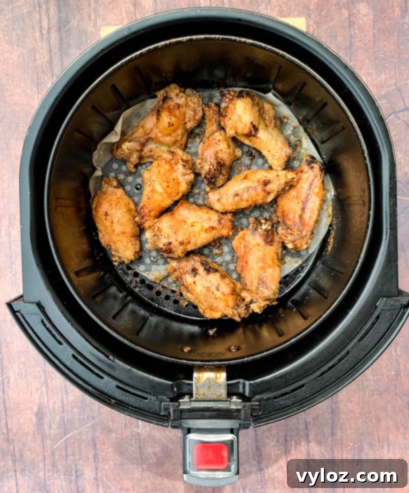 Keto breaded chicken wings cooking in an air fryer basket