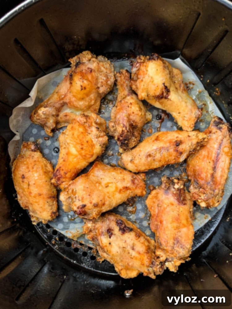 Close-up of crispy keto breaded chicken wings cooking in an air fryer