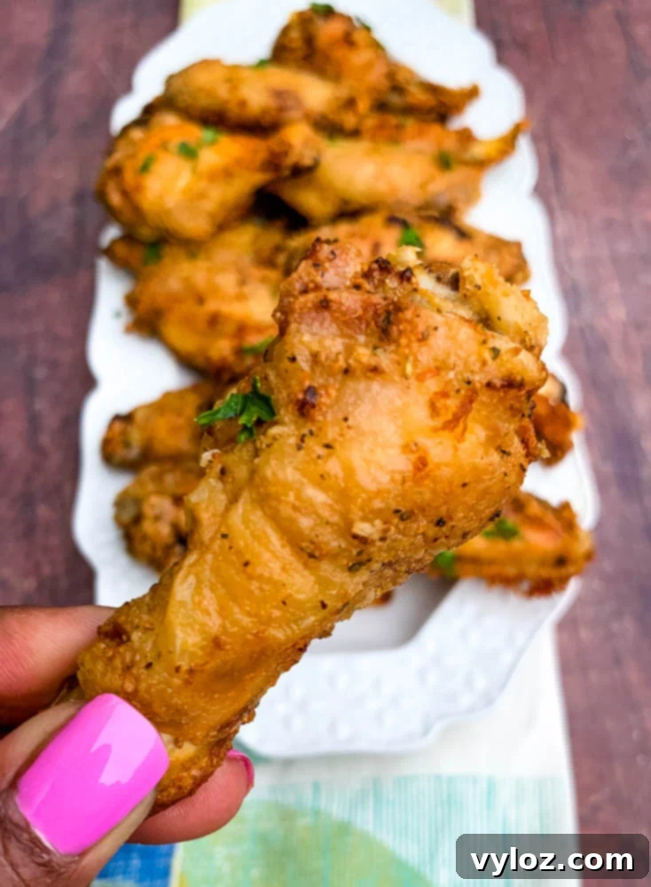 Person holding a plate of air fryer keto fried chicken wings
