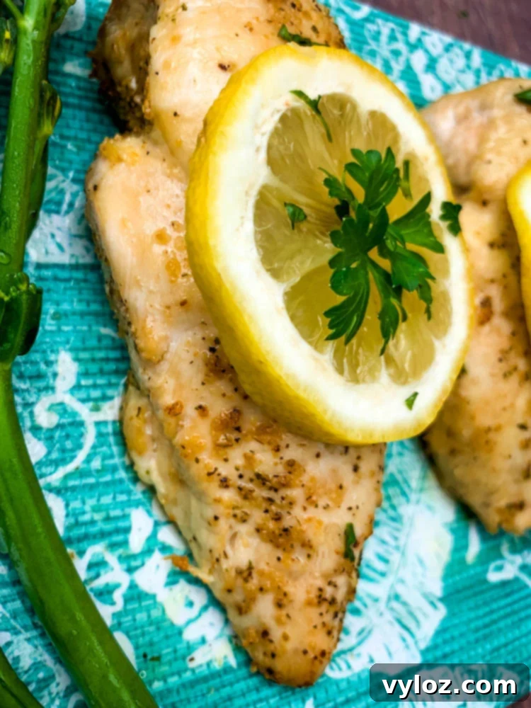 air fryer chicken breast on a blue plate with broccoli and lemons