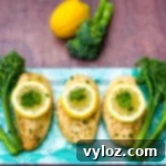 air fryer chicken breast on a blue plate with broccoli and lemons