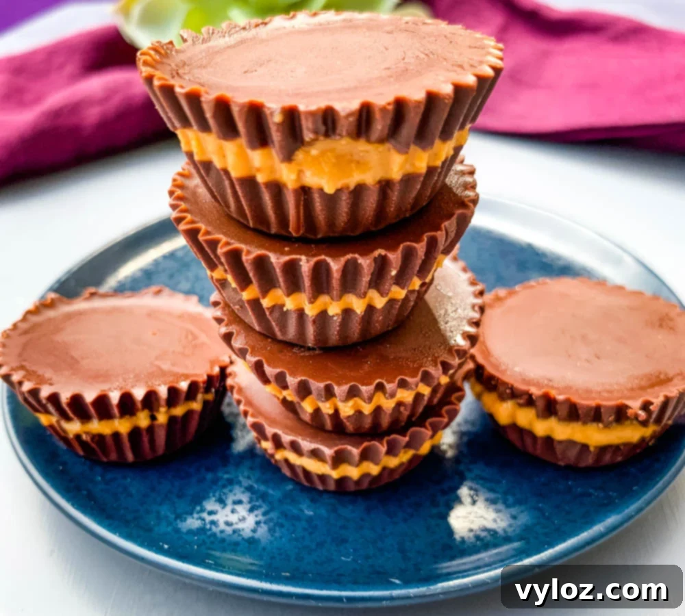 Sugar-free peanut butter cups arranged on a vibrant blue plate, showcasing their smooth chocolate coating.