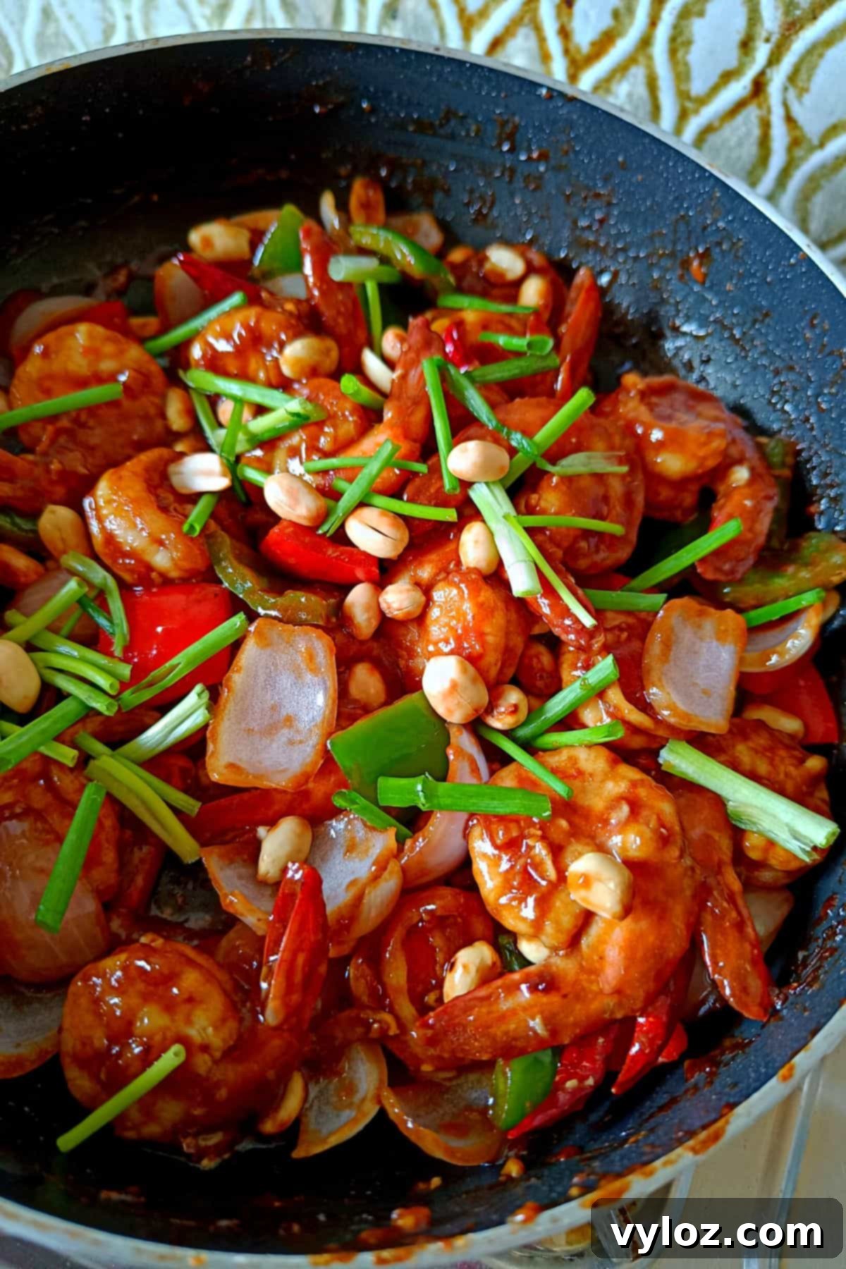Whip Up Kung Pao Shrimp in Minutes 2 Image showing shrimp kung pao in a pan topped with peanuts and scallions, showcasing its appealing colors and textures.