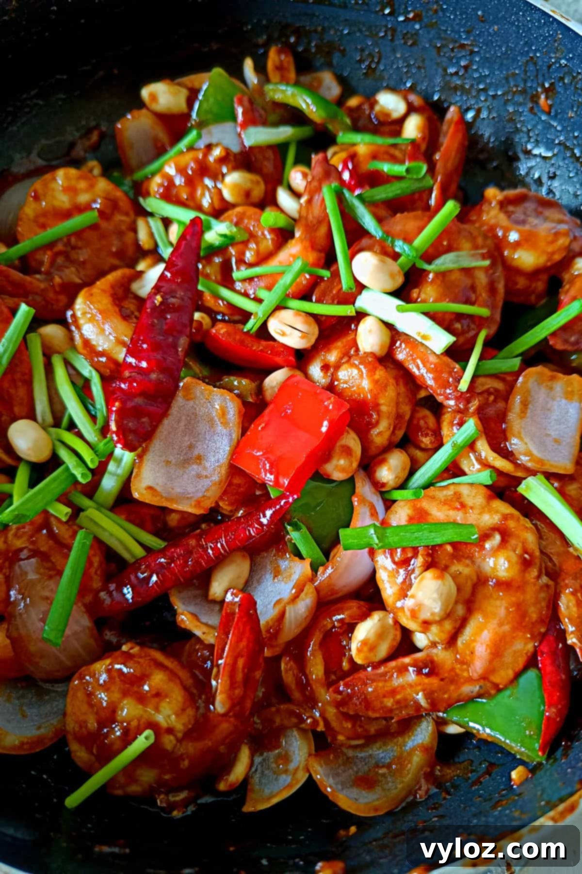 Whip Up Kung Pao Shrimp in Minutes 3 Image showing vibrant looking shrimp kung pao topped with peanuts and scallion greens, ready to be served.