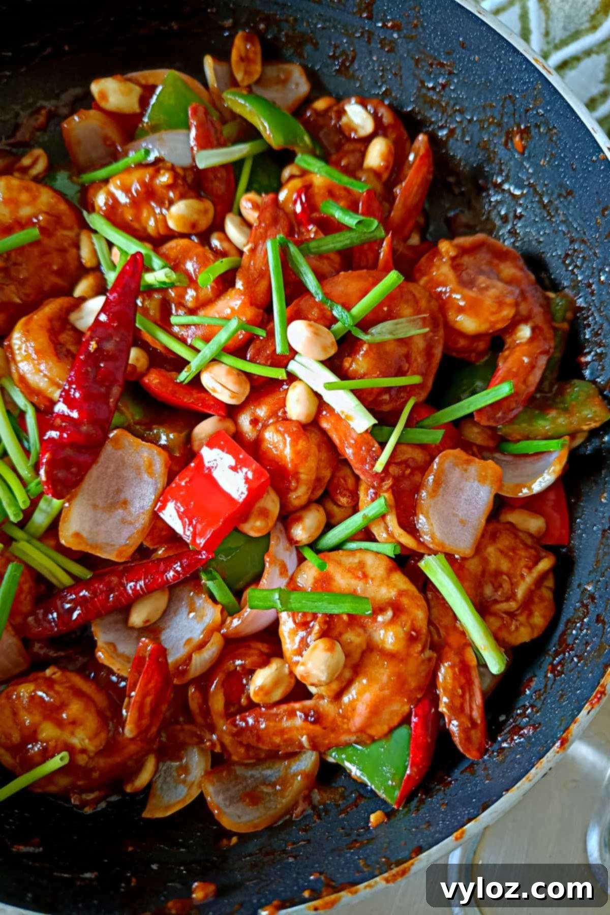 Whip Up Kung Pao Shrimp in Minutes 7 Image showing tender, juicy shrimps coated with glossy kung pao sauce, generously topped with peanuts and fresh scallions, ready to be enjoyed.