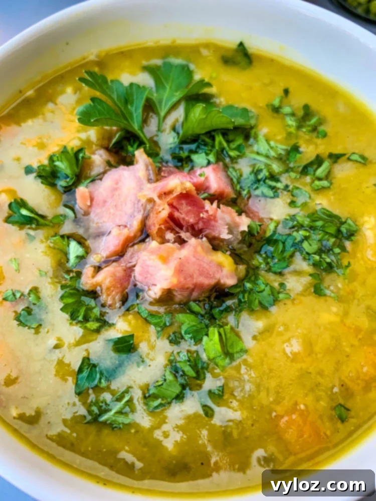 A close-up shot of a white bowl filled with creamy Instant Pot Split Pea Soup, highlighting its rich texture and savory appeal.