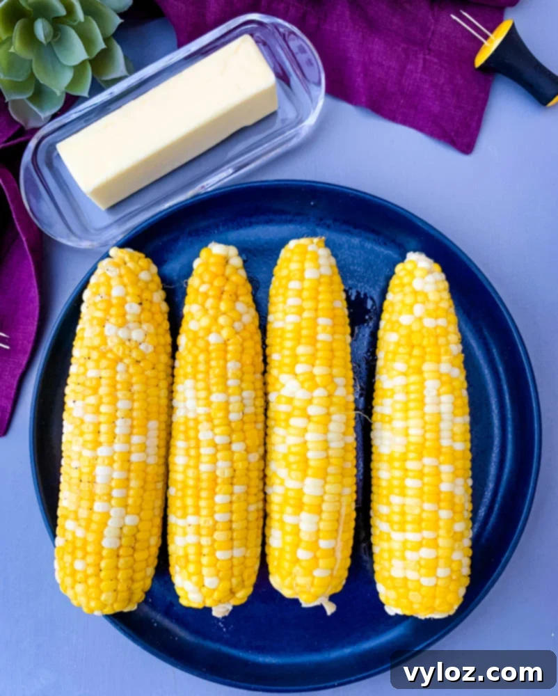 instant pot corn on the cob on a blue plate with a purple napkin, ready to serve.