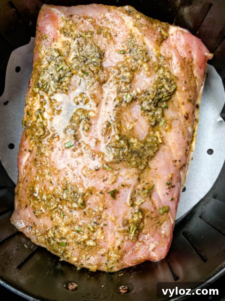 raw air fryer pork loin in an air fryer basket