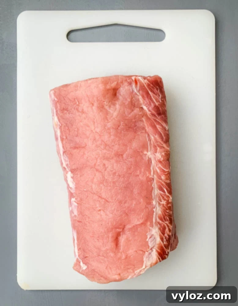raw pork loin roast on a cutting board