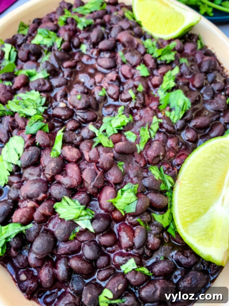 instant pot black beans in a blue bowl with cilantro and lime