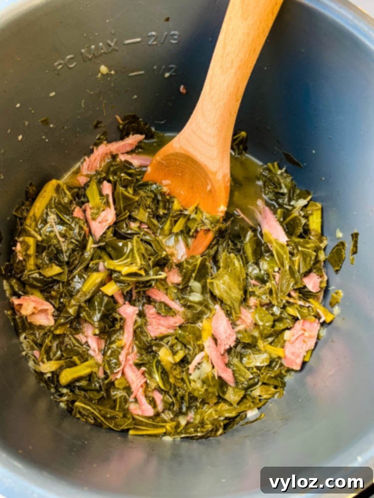 Soulful Instant Pot Southern Collard Greens 7 Cooked collard greens in an Instant Pot with a wooden spoon