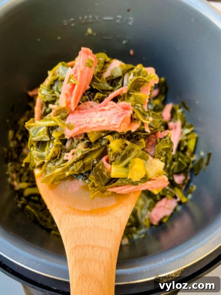 Soulful Instant Pot Southern Collard Greens 10 Cooked collard greens in an Instant Pot with a wooden spoon