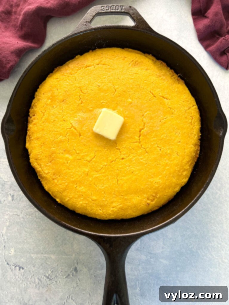 baked cornbread in a cast iron skillet with butter on top