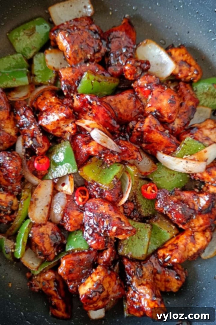 Quick and Easy Black Pepper Chicken 2 Image showing black pepper chicken stir fry in a nonstick pan.