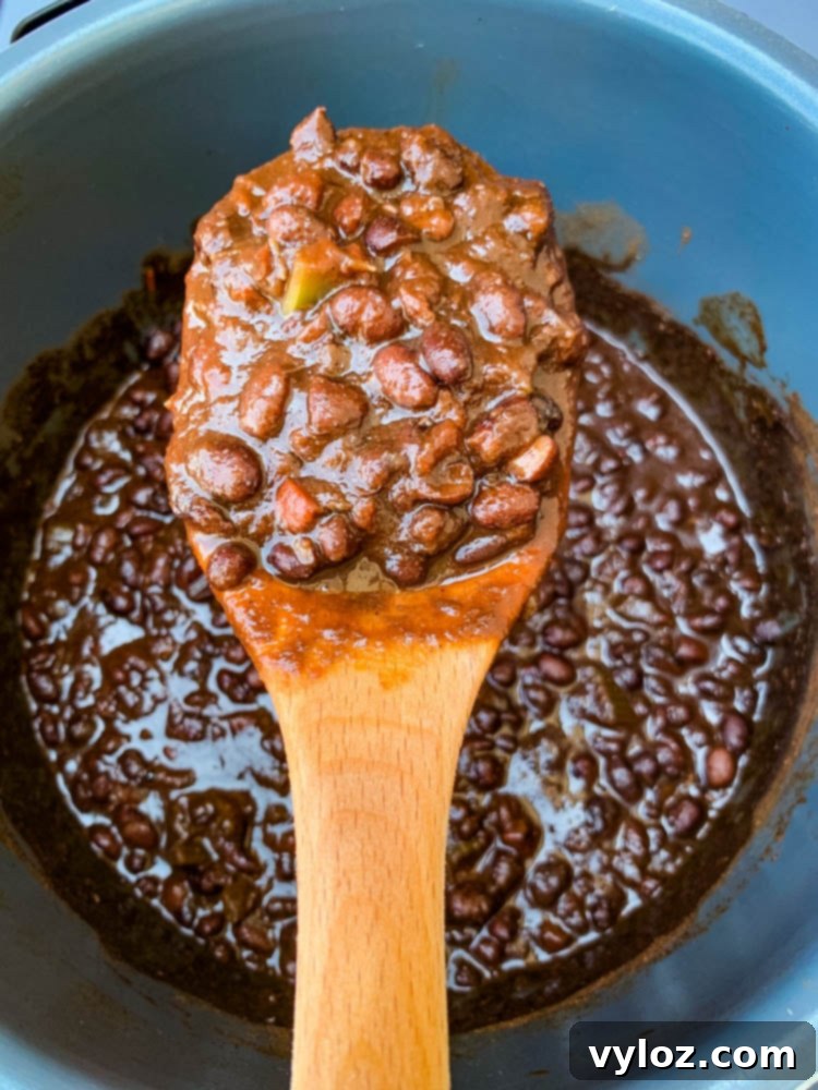 Simple & Savory Instant Pot Black Bean Soup 6 a wooden spoon filled with Instant Pot black bean soup