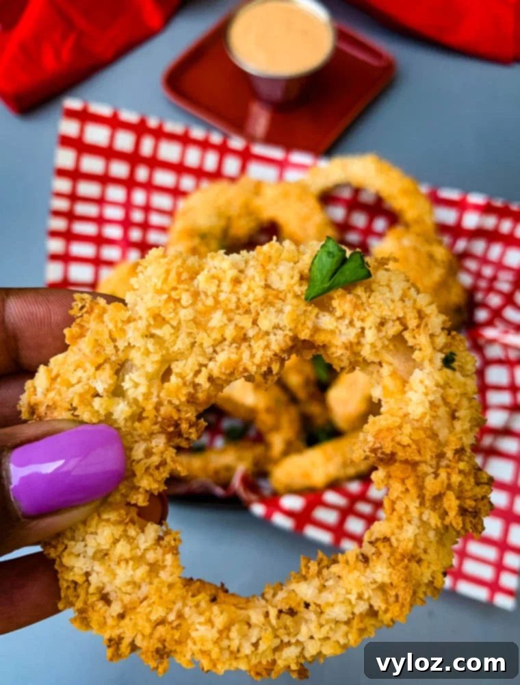 person holding air fryer onion ring