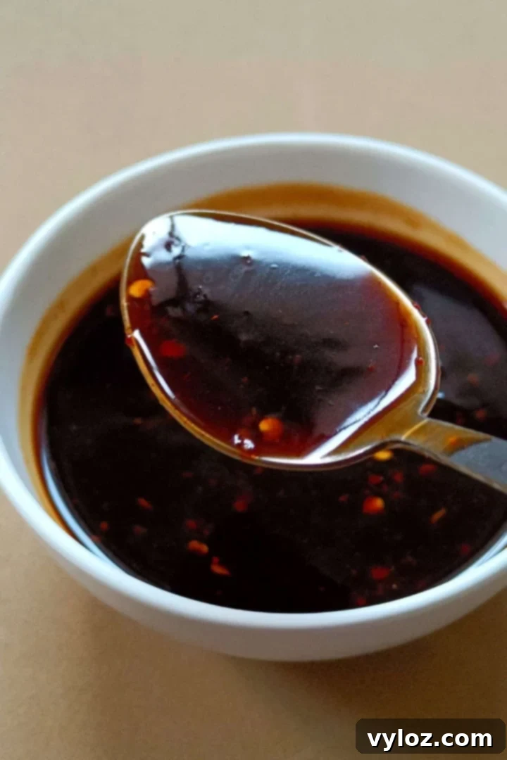 Homemade Asian Zing Wing Sauce 2 A glistening bowl of homemade Asian Zing Sauce, garnished with sesame seeds, ready to be served.