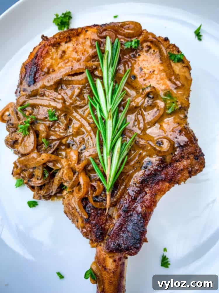 Smothered Keto Pork Chops 11 Keto smothered pork chops on a white plate, garnished and ready to eat