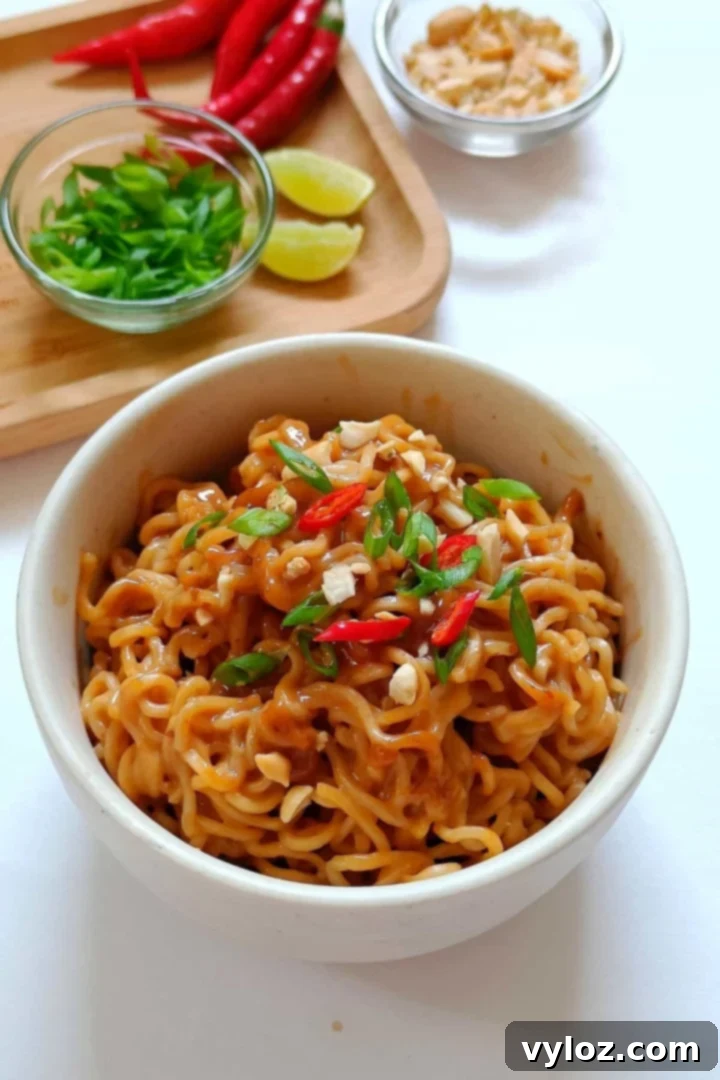 Image showing creamy peanut butter noodles served in a white bowl.