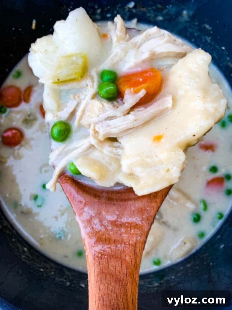 Instant Pot chicken and dumplings from scratch served with a wooden spoon directly from the Instant Pot.