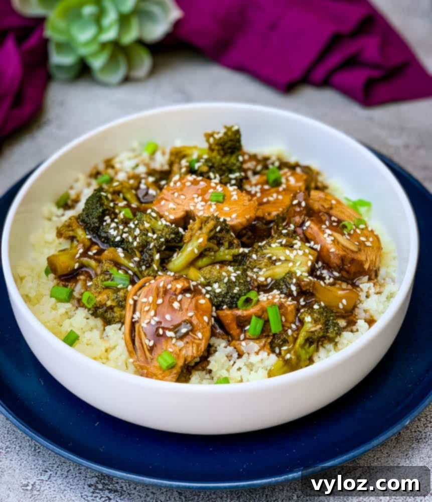 Instant Pot teriyaki chicken in a white bowl, garnished with sesame seeds and green onions