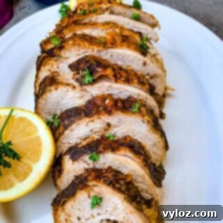 air fryer roasted turkey breast on a white plate with sliced lemon