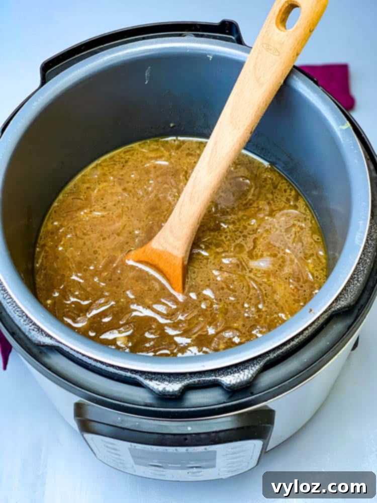 Effortless Instant Pot French Onion Soup 7 Instant Pot French Onion Soup with a wooden spoon