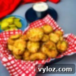 air fryer crunchy fried pickles in a basket with a side of ranch dressing