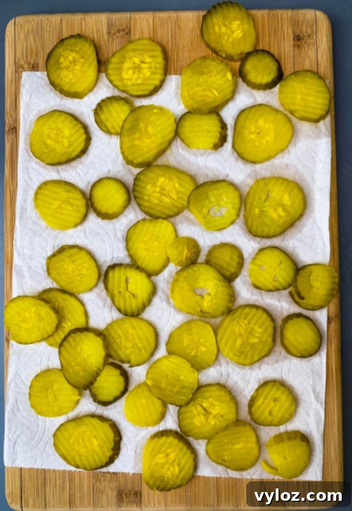 pickles laid on a paper towel on a cutting board