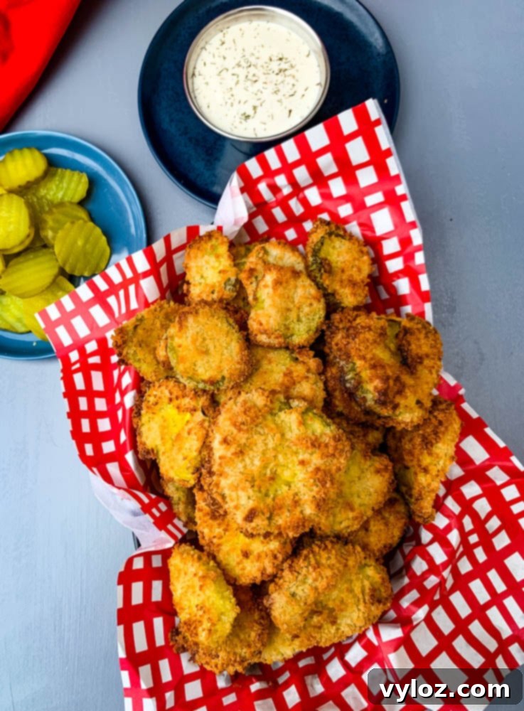 air fryer crunchy fried pickles in a basket with a side of ranch dressing